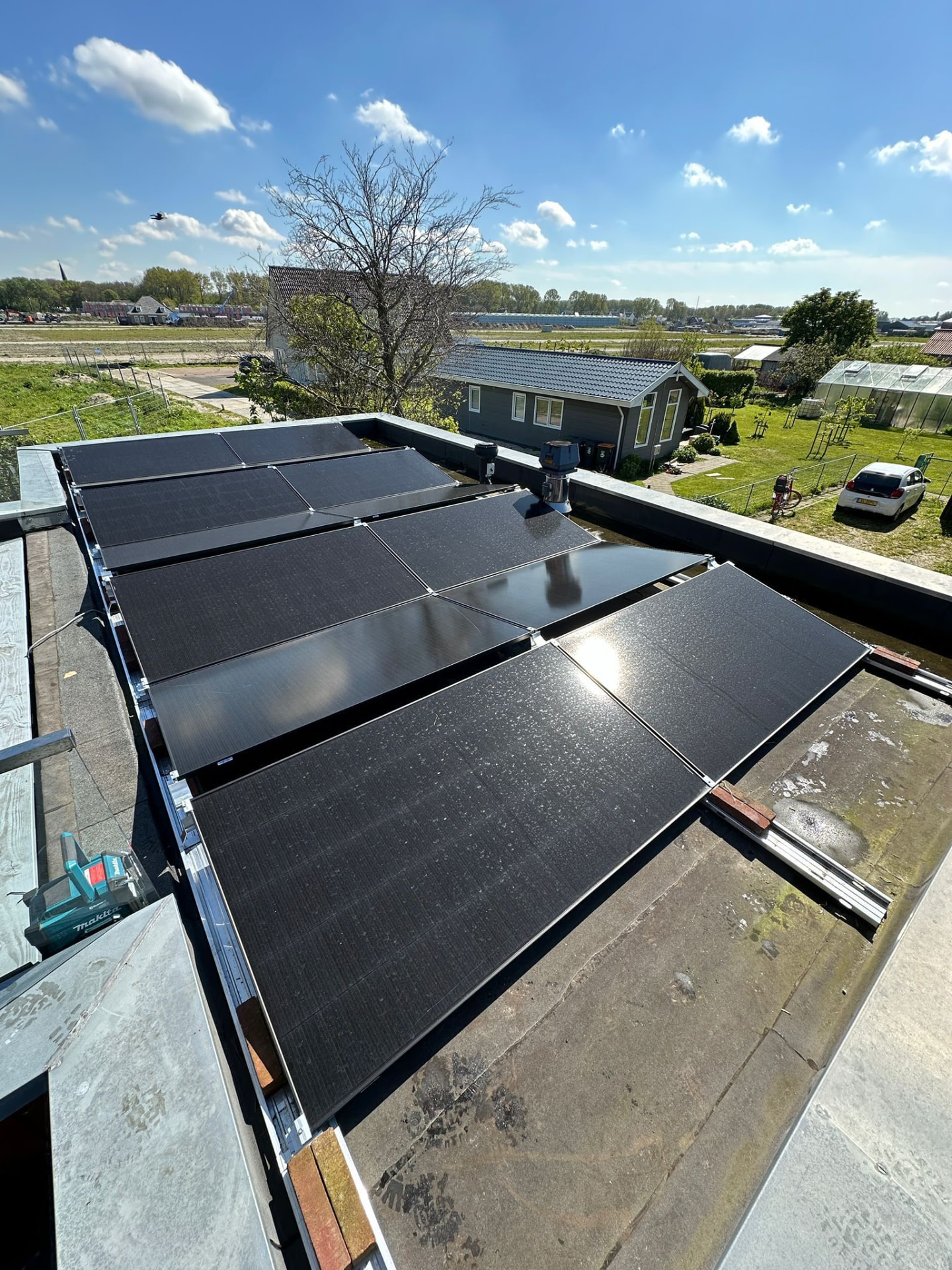 Zonnepanelen in rijen op een plat dak met zwart ballastsysteem